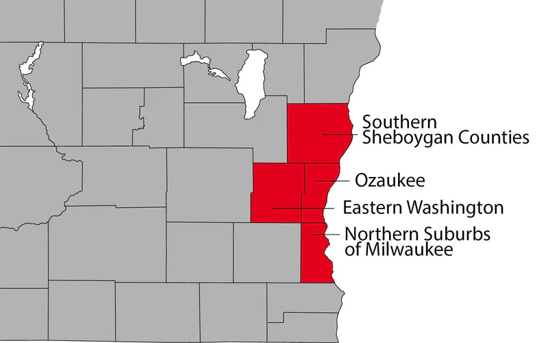 Service area map from jamesheatingandac.com: county outlines of eastern Wisconsin with four counties along the Lake Michigan shore filled in red and labelled Southern Sheboygan Counties, Ozaukee, Eastern Washington, and Northern Suburbs of Milwaukee